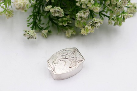 Caixa de comprimidos em prata guilhochada com gravados vegetalistas na tampa